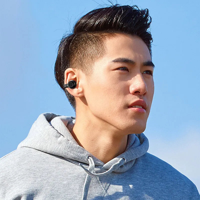 Wireless bone conduction clip-on Bluetooth earphones in black or white with charging cable