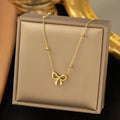 Gold electroplated bow necklace with titanium steel cross chain, adjustable 41-50cm length