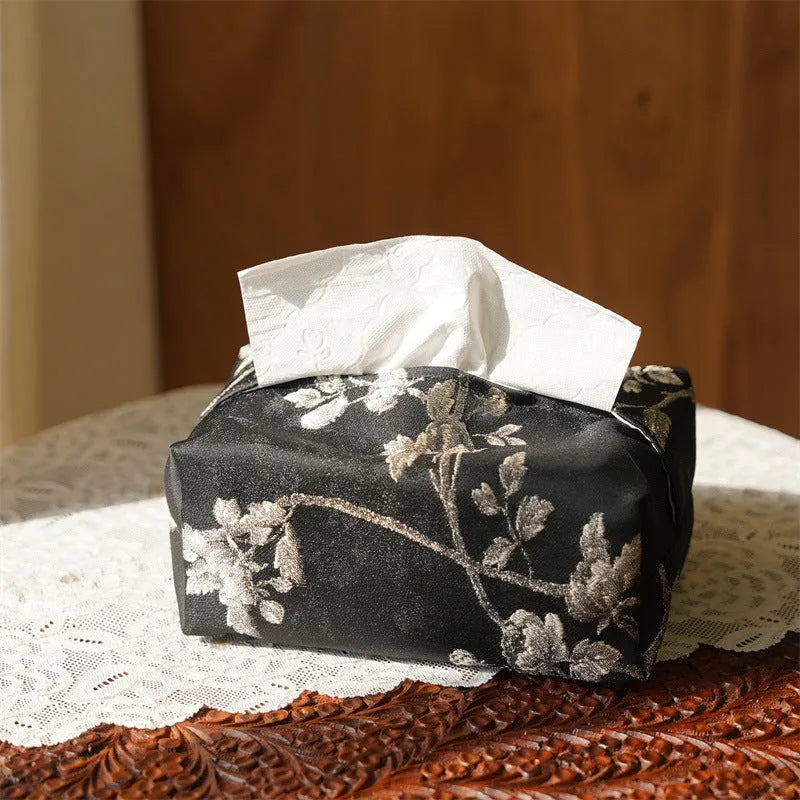 White Chinese brocade tissue box cover with embroidered plum blossoms, shown with and without a pearl buckle.