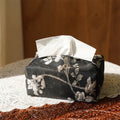 White Chinese brocade tissue box cover with embroidered plum blossoms, shown with and without a pearl buckle.