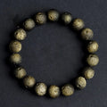 Close-up of a natural obsidian crater ball bracelet with grinding-treated beads on a wrist.
