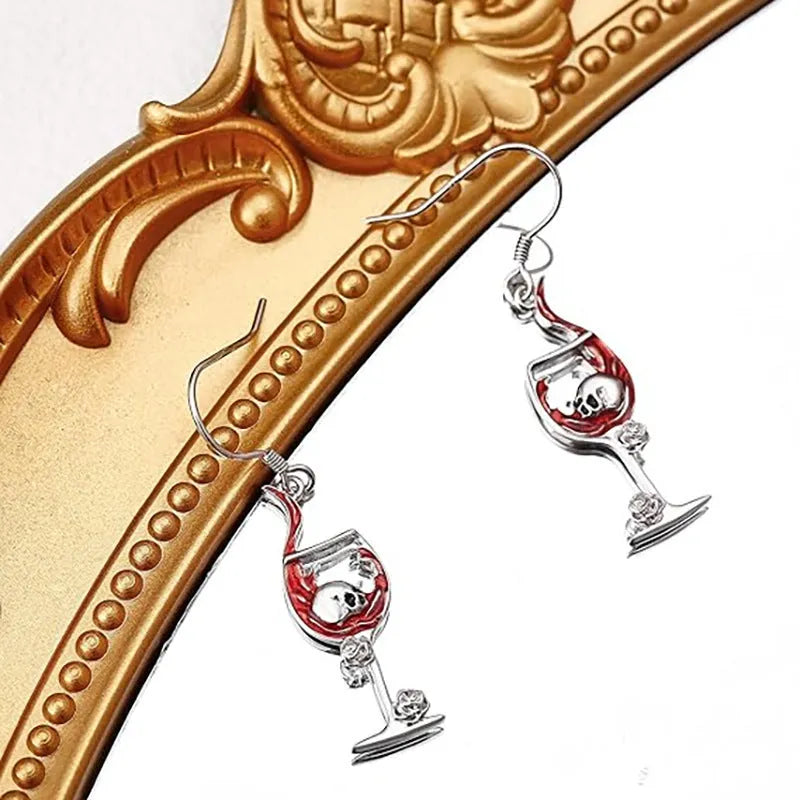 A pair of silver-toned geometric skull earrings for pierced ears on a plain background.