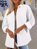 Women's solid colour long-sleeved knitted cardigan in black, shown in a casual setting.