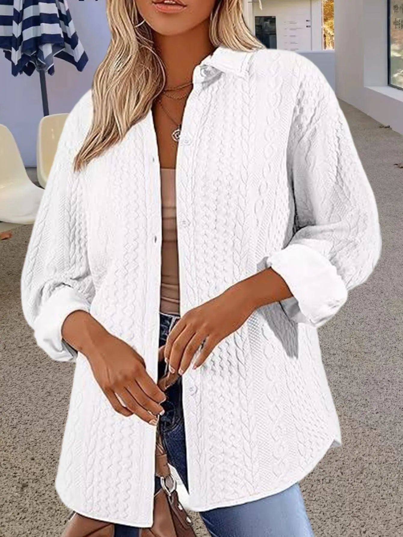 Women's solid colour long-sleeved knitted cardigan in black, shown in a casual setting.