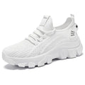 Women's white Flyknit running sneakers with lace-up front and thick PVC sole on a neutral background.
