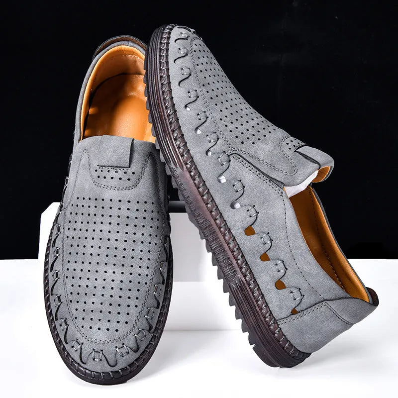 Men's brown leather slip-on casual shoes with flat sole, round toe, and decorative stitching.