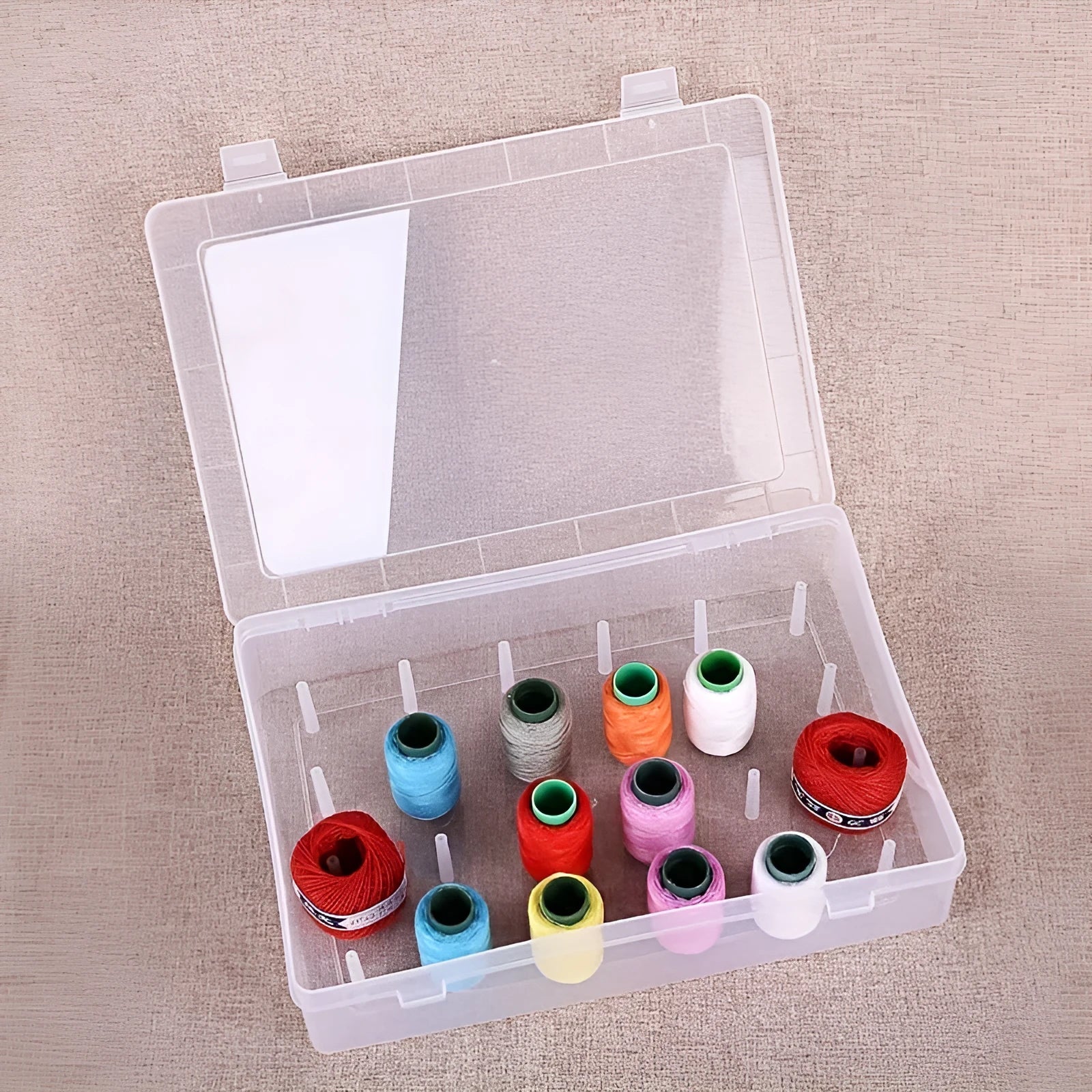 A 42-compartment transparent plastic sewing storage box for organising embroidery threads and needles.