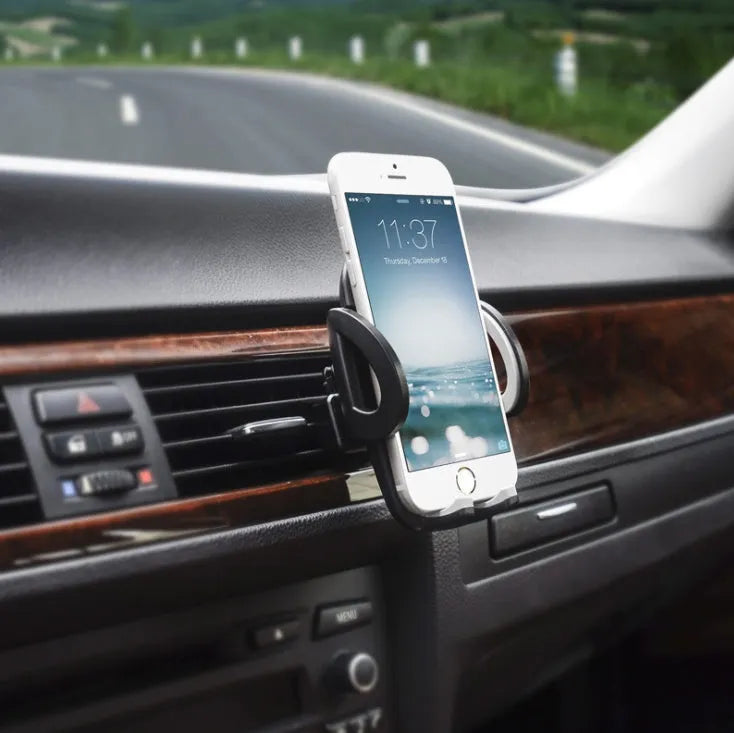 Black plastic mobile phone holder attached to car air conditioning outlet for hands-free navigation