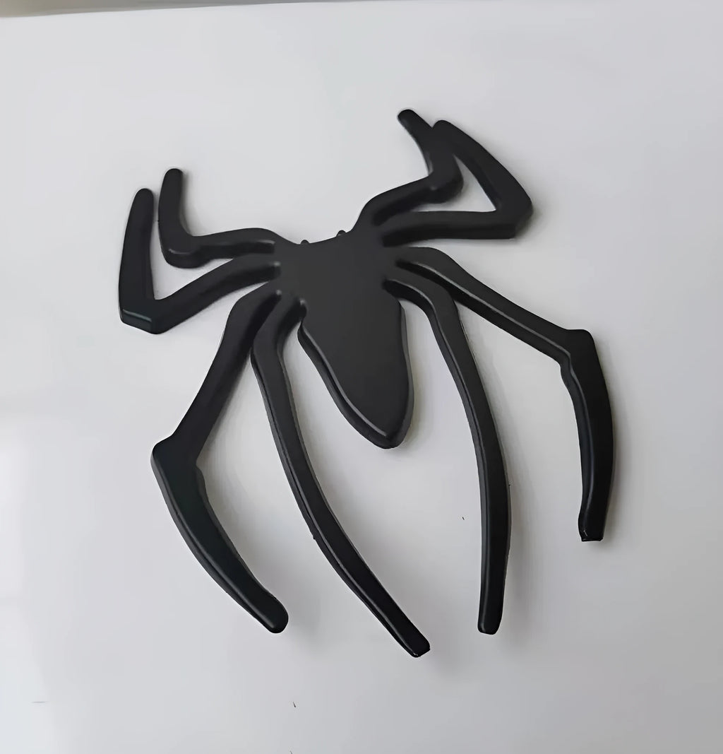 Three-dimensional metal spider car sticker in gold, silver, black, or red.