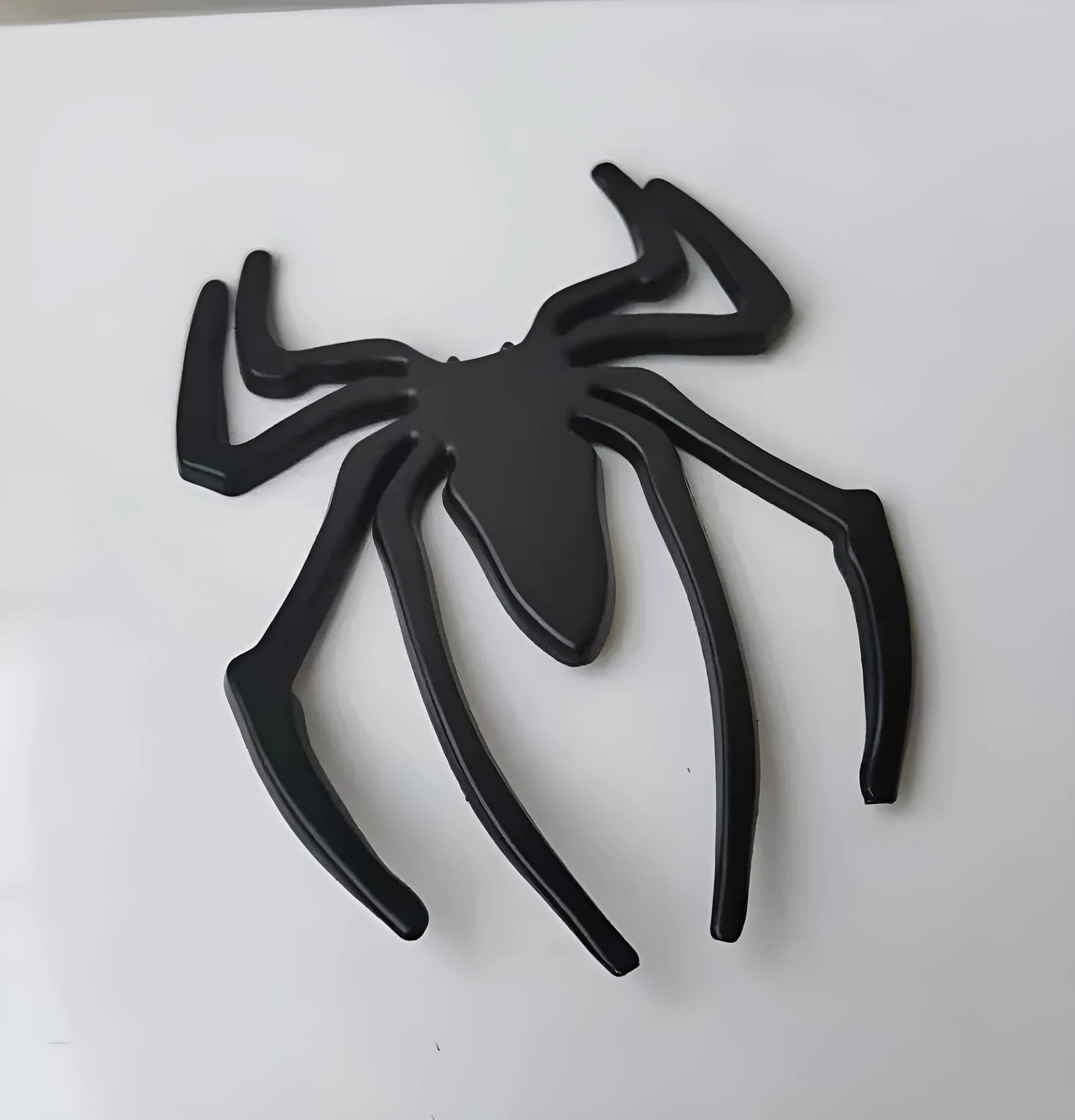 Three-dimensional metal spider car sticker in gold, silver, black, or red.