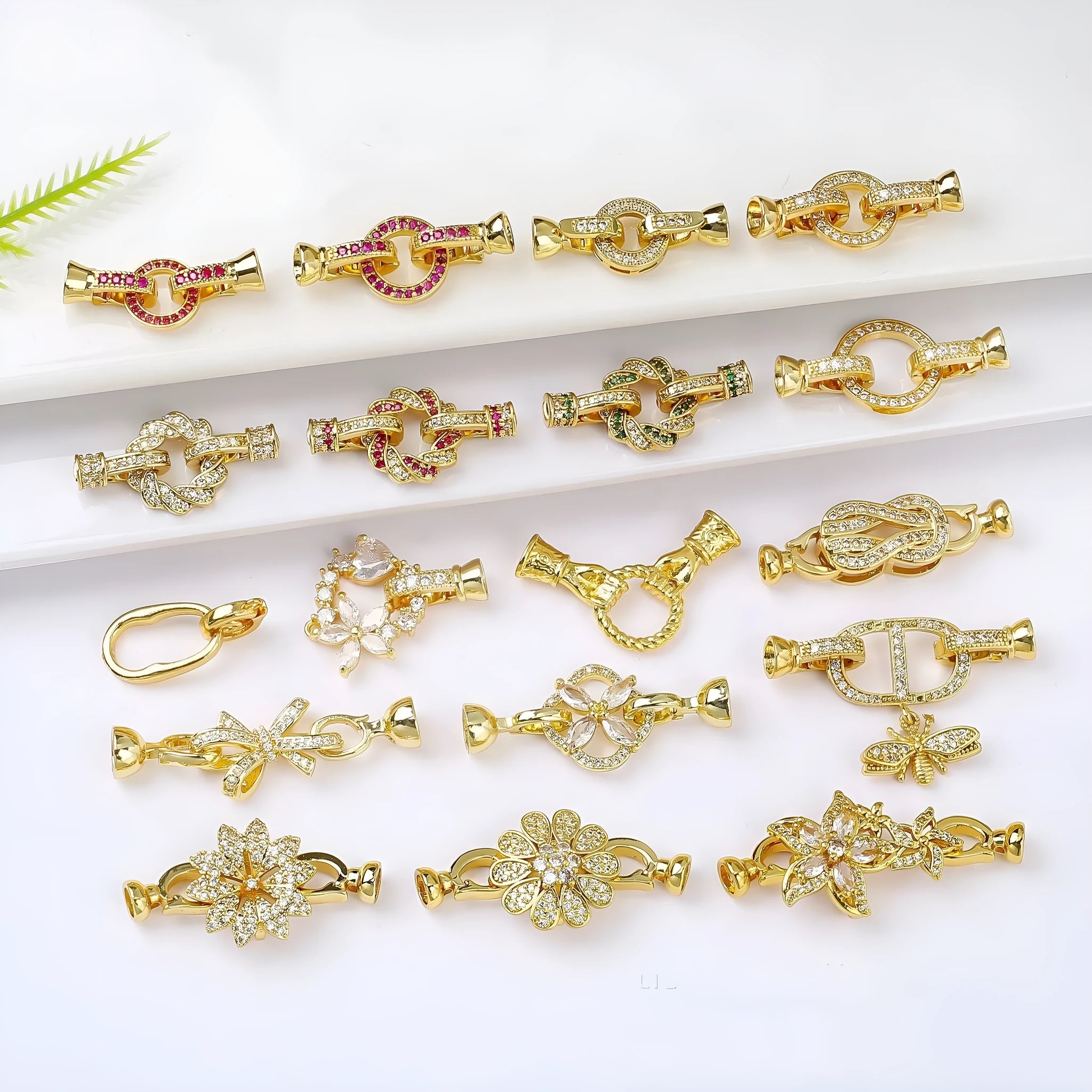 Small gold-colour metal jewellery clasp with a white pearl detail on the buckle