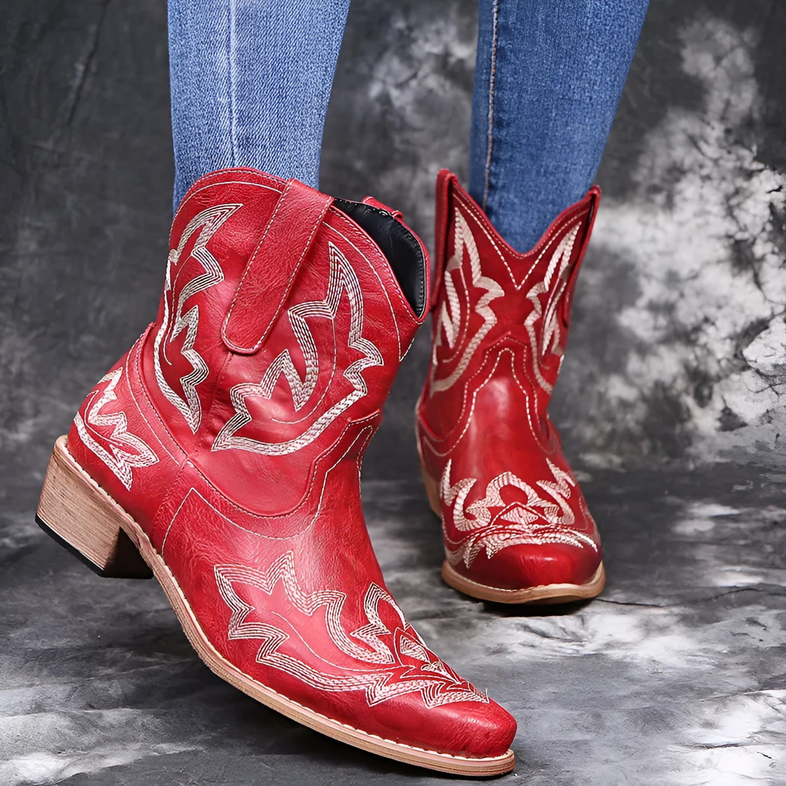 Women's blue cowboy boot with embroidery detail on the side, low wedge heel, and pointed toe.