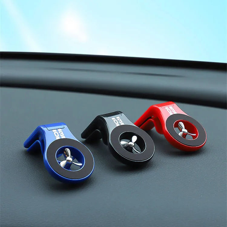 Black magnetic car phone holder attached to a car air vent, holding a smartphone at an angle.