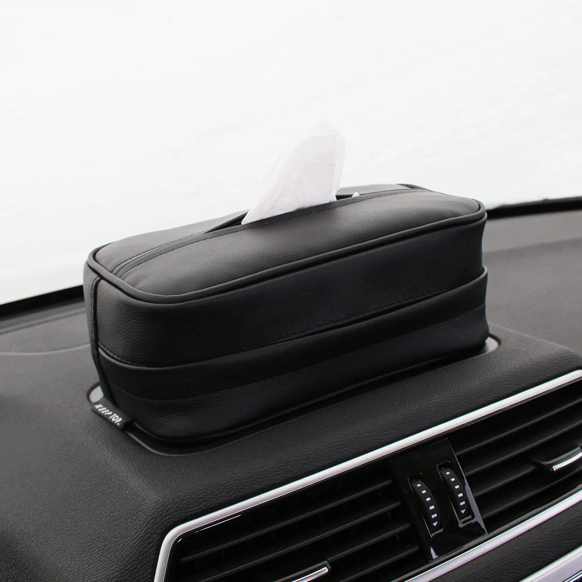 Black PU leather car storage box with hanging straps shown on a car headrest.