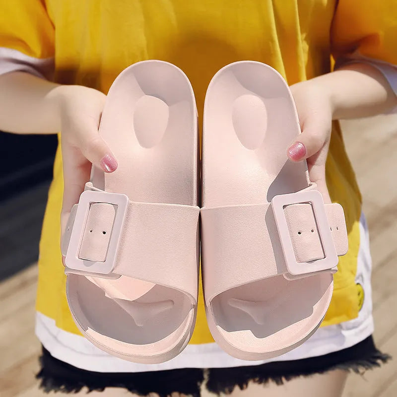 Women's grey-blue EVA flip-flop slippers with a silver buckle fastening on a white background.