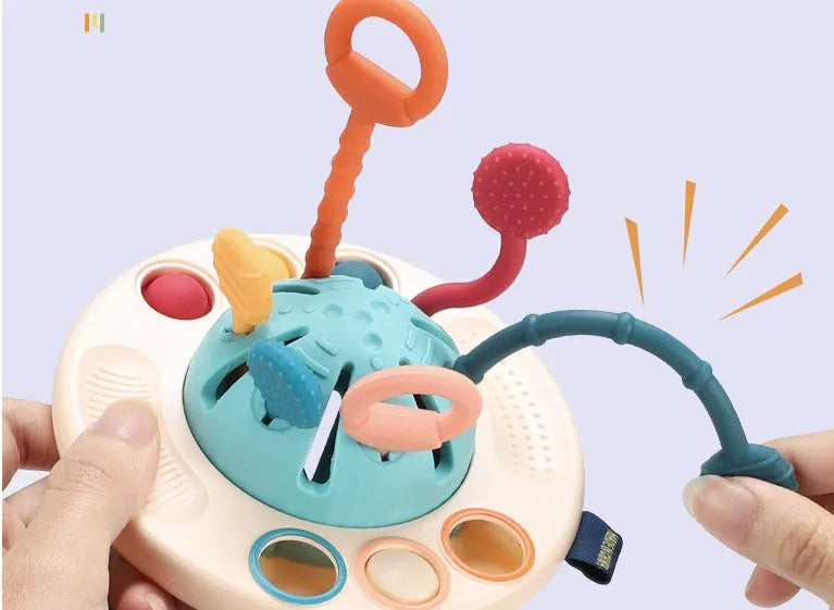 Silicone sensory training toy for baby, 12x21cm flying saucer shape with pull rope and small ball, Montessori finger toy for 18m+.