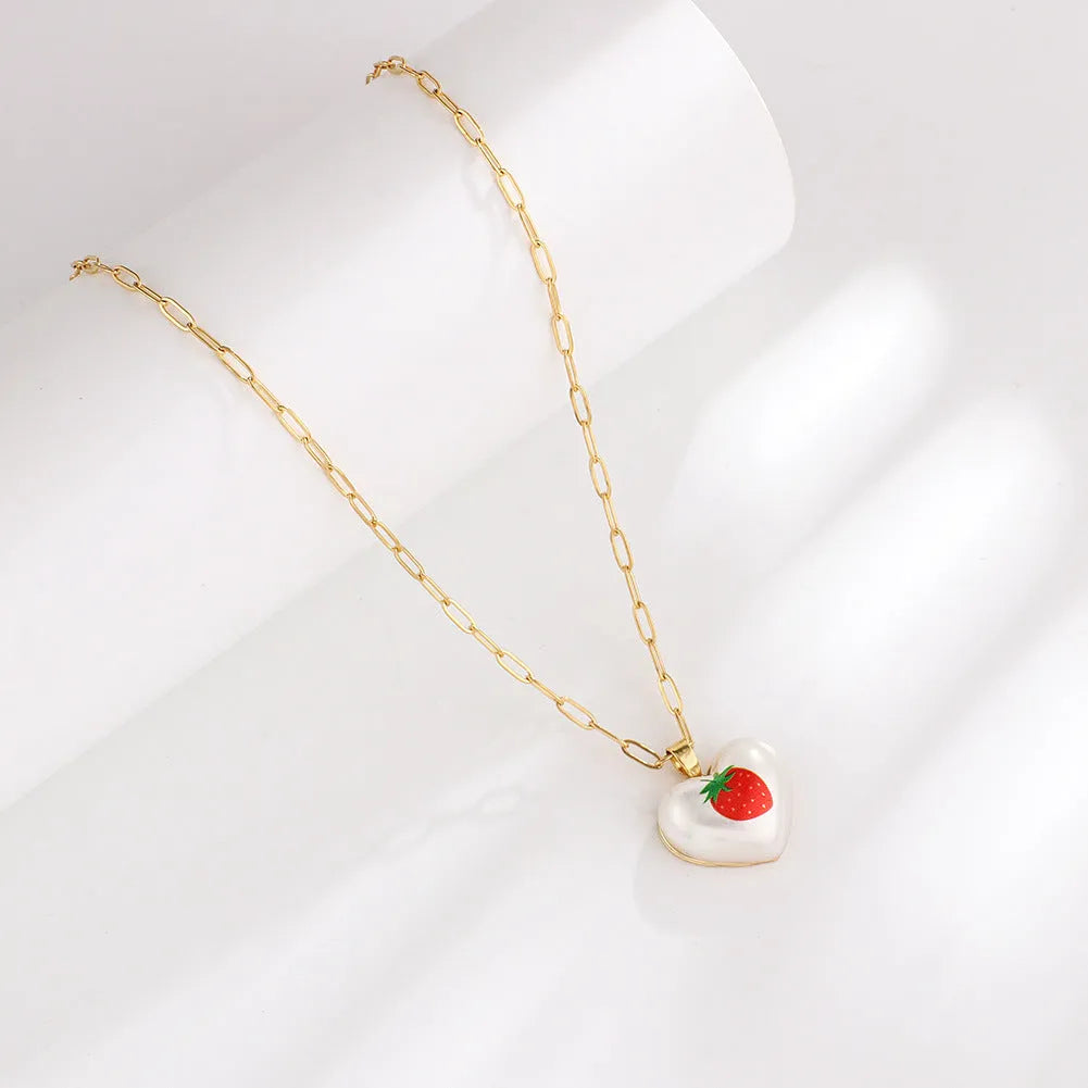 Geometric heart-shaped necklace with a choice of strawberry, pineapple, apple, pear or cherry pendant on an adjustable chain.