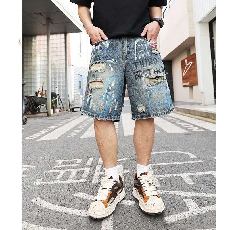 Men's blue ripped jeans shorts with graffiti detail, straight leg cut, and zipper fly closure