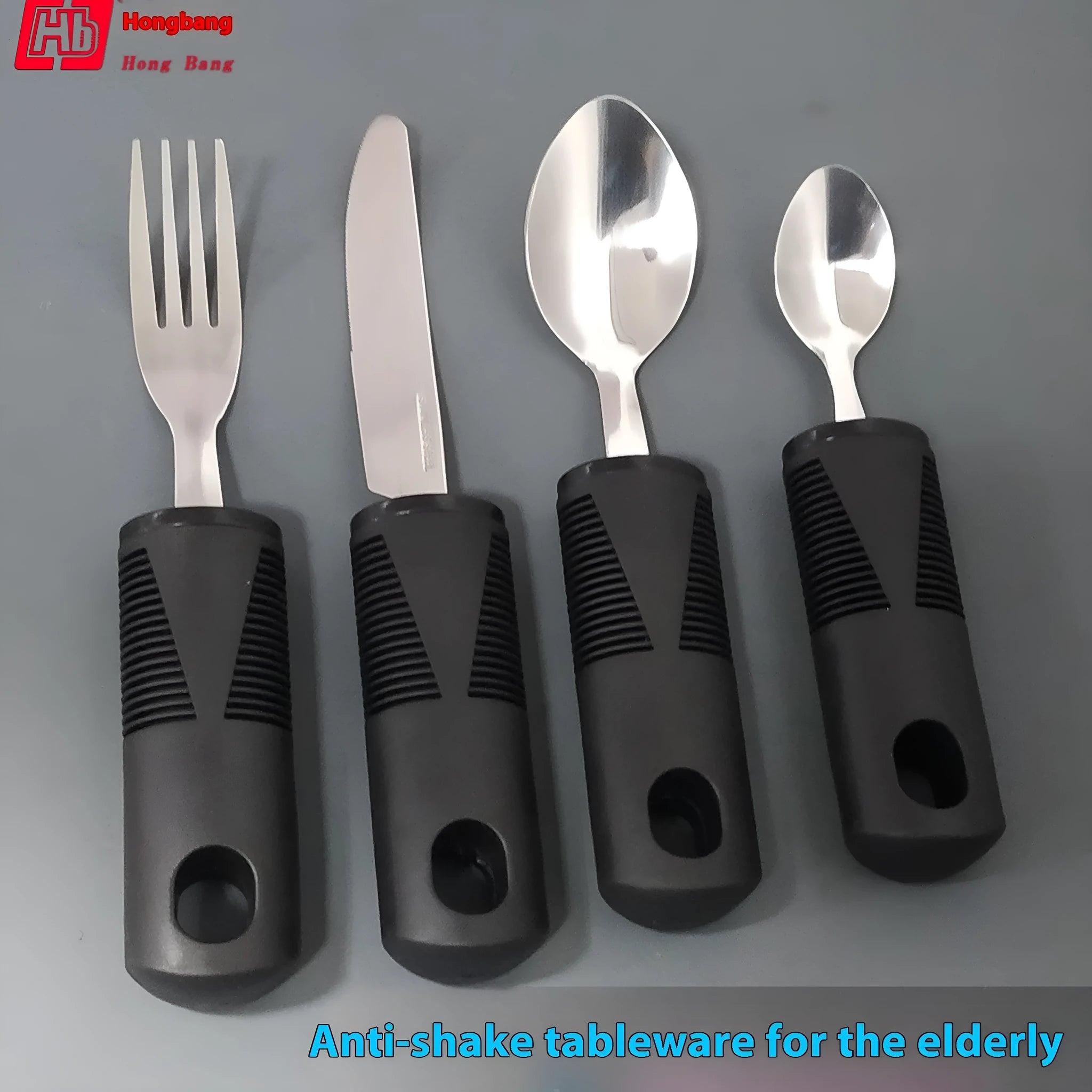 Stainless steel adaptive knife, fork, and spoon set with black rubberised easy-grip handles.