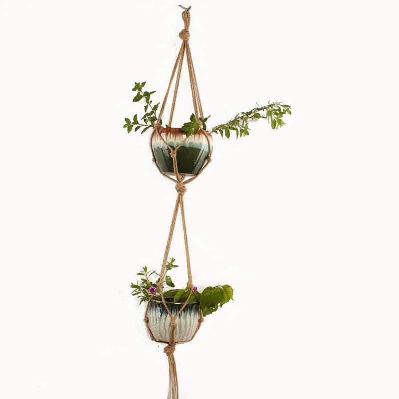 Woven wire cotton rope rustic hanging basket plant holder on a wall.