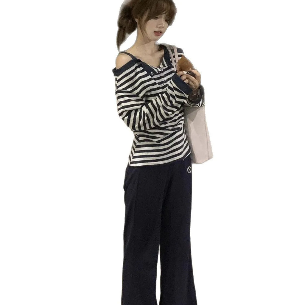 Dark blue women's long-sleeved oversized T-shirt with embroidery and striped detail on a hanger.