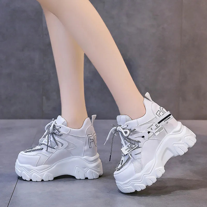 White women's low-top mesh sneakers with a black cross strap and a thick rubber platform sole.