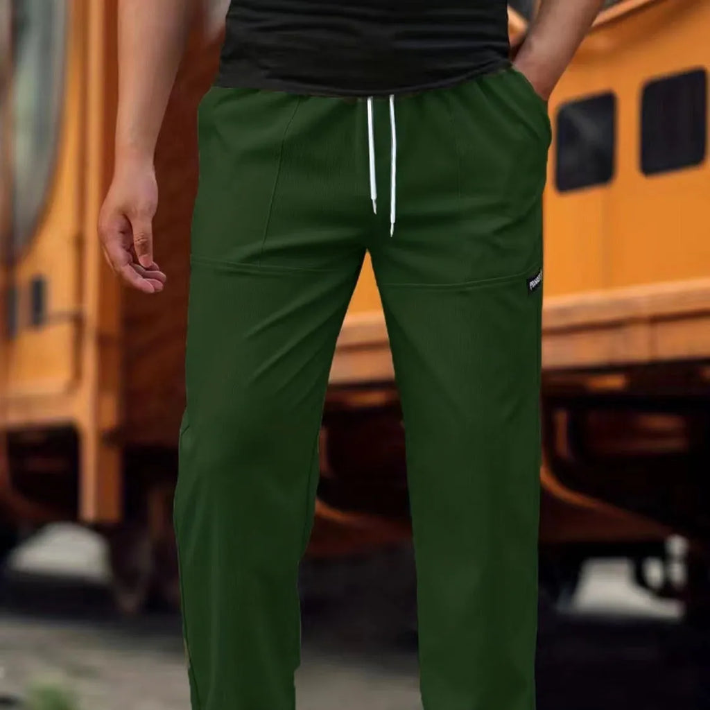 Men's light grey tapered slim-fit trousers with an elastic waistband on a hanger.