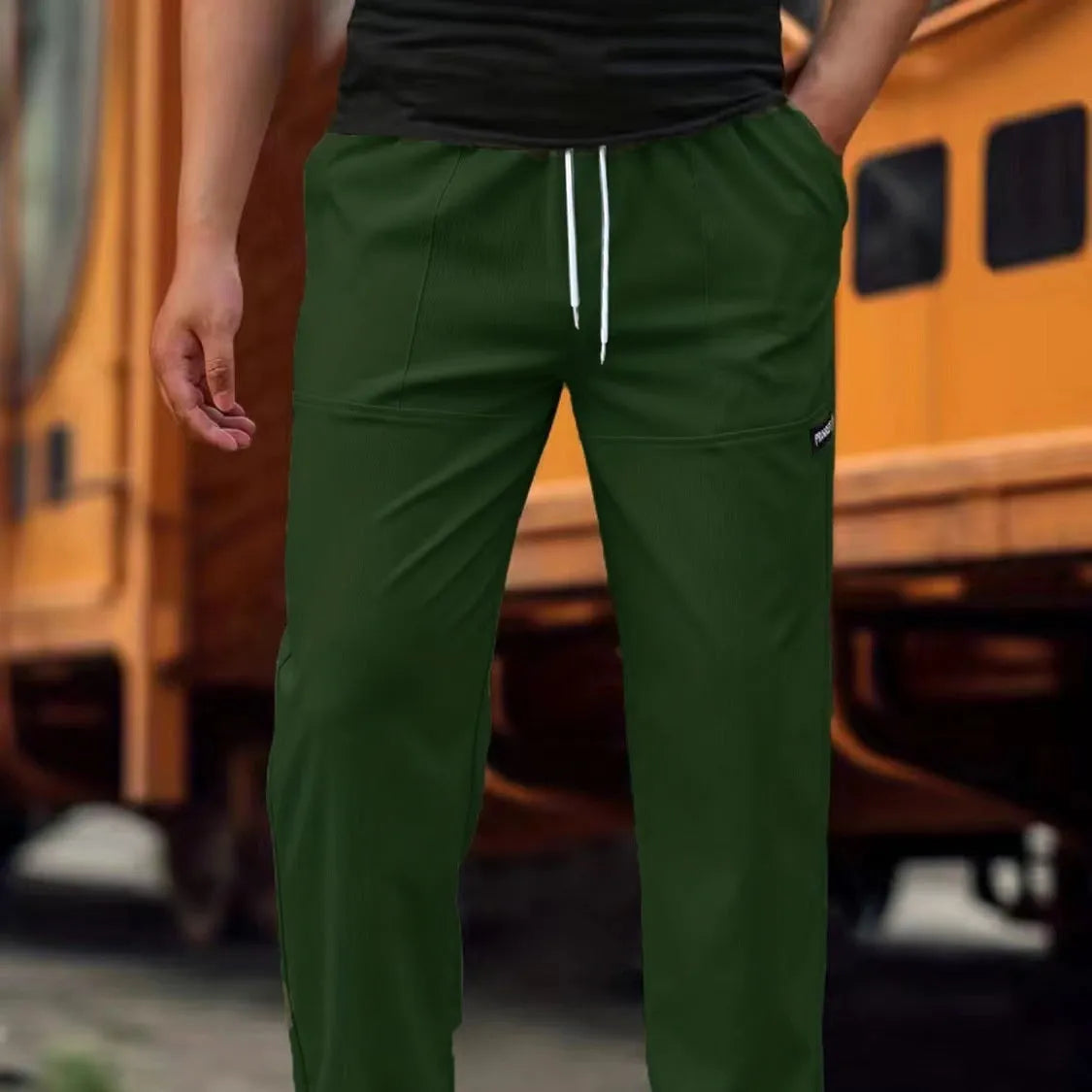 Men's light grey tapered slim-fit trousers with an elastic waistband on a hanger.