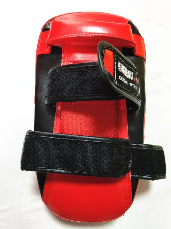 Red and black square hand-held martial arts training pad for kicks and punches.