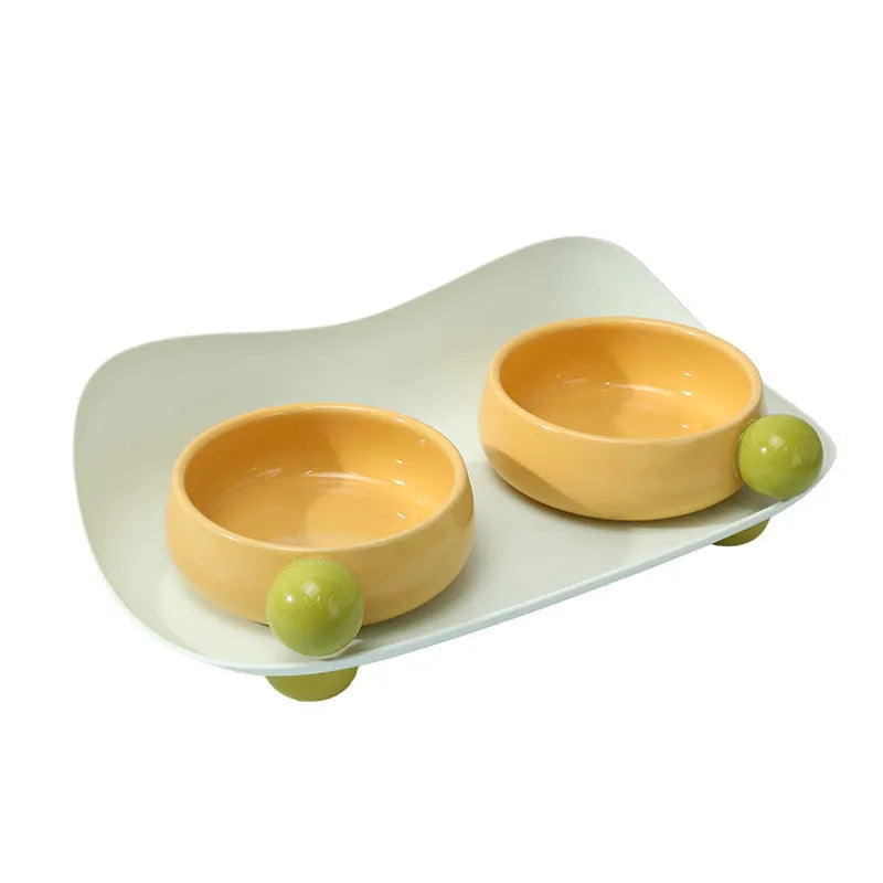 Elevated ceramic pet feeder with two bowls and non-slip base in pink, for cats and small dogs.