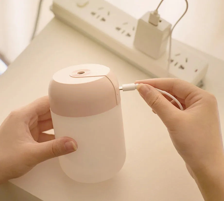 White cylindrical USB-powered mini humidifier with charging cable
