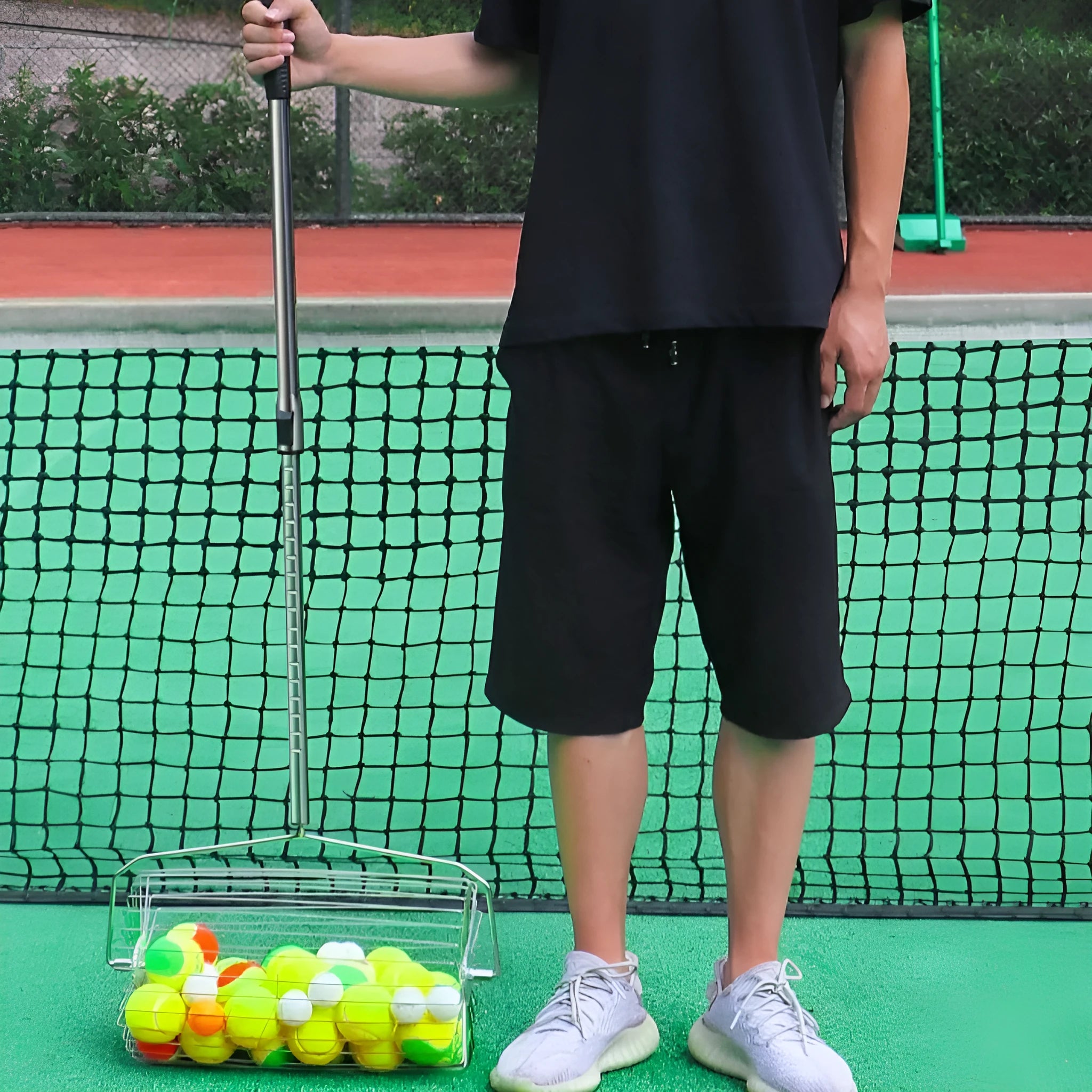 Stainless steel roller tennis ball picker with adjustable telescopic handle.