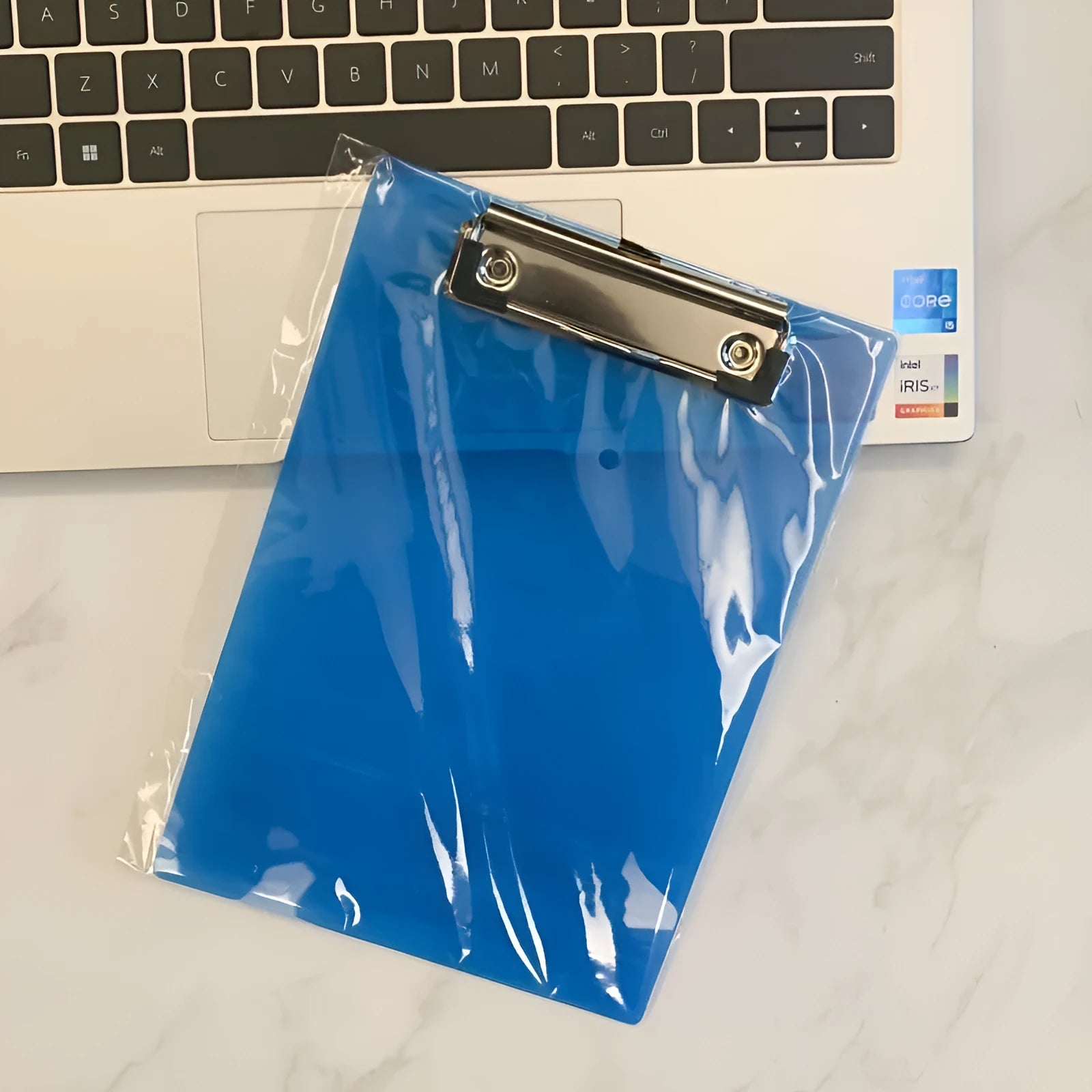 Transparent A4 plate holder with metal clip, shown in blue, acting as a writing board and document folder.