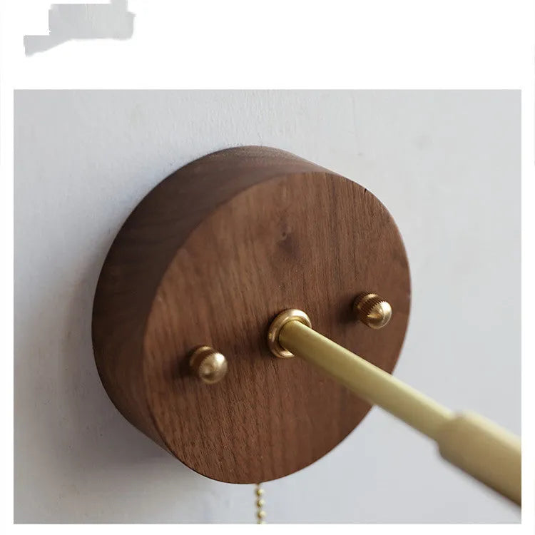 Inn Niche Nordic style wooden bedside wall lamp in walnut colour mounted on a light wall.