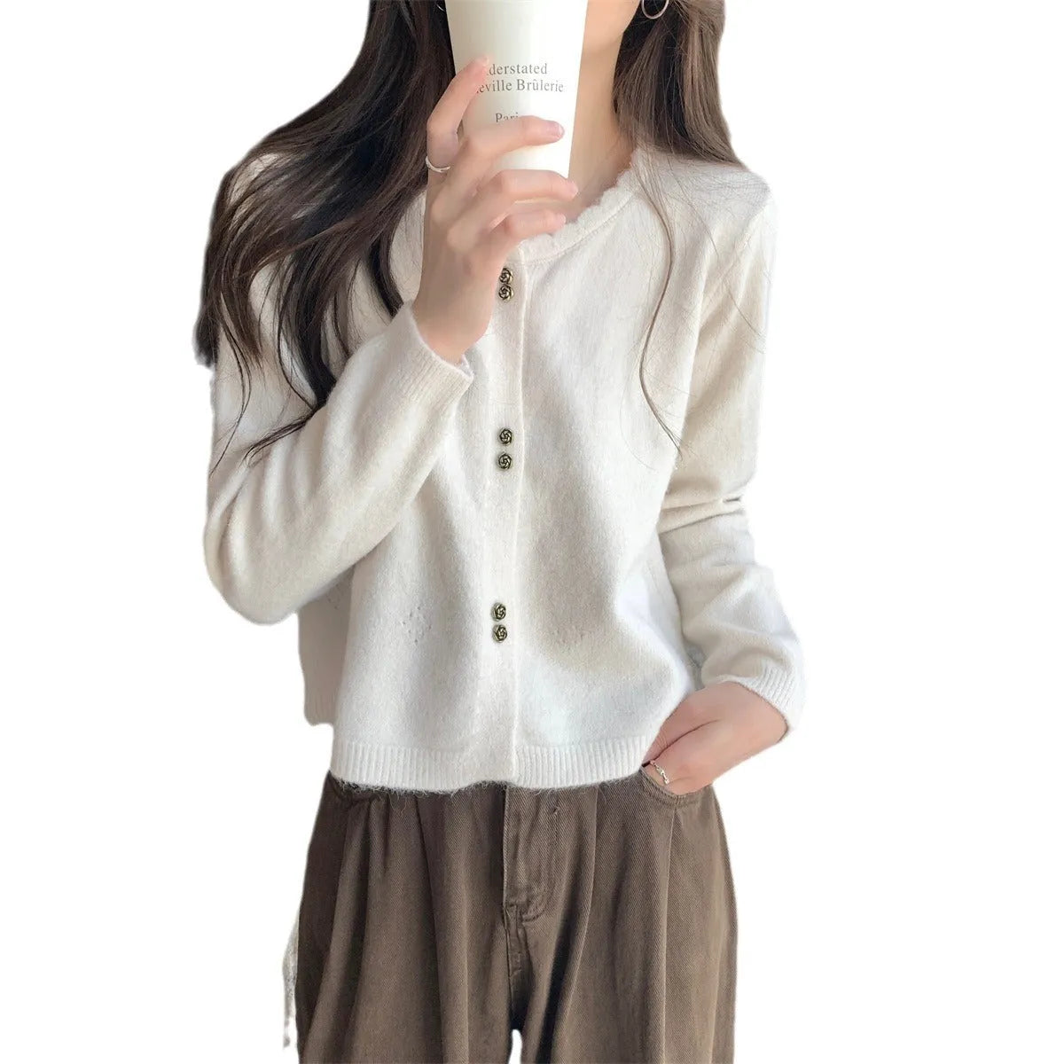 Women's milky white long-sleeved acrylic cardigan coat worn open as a layer.