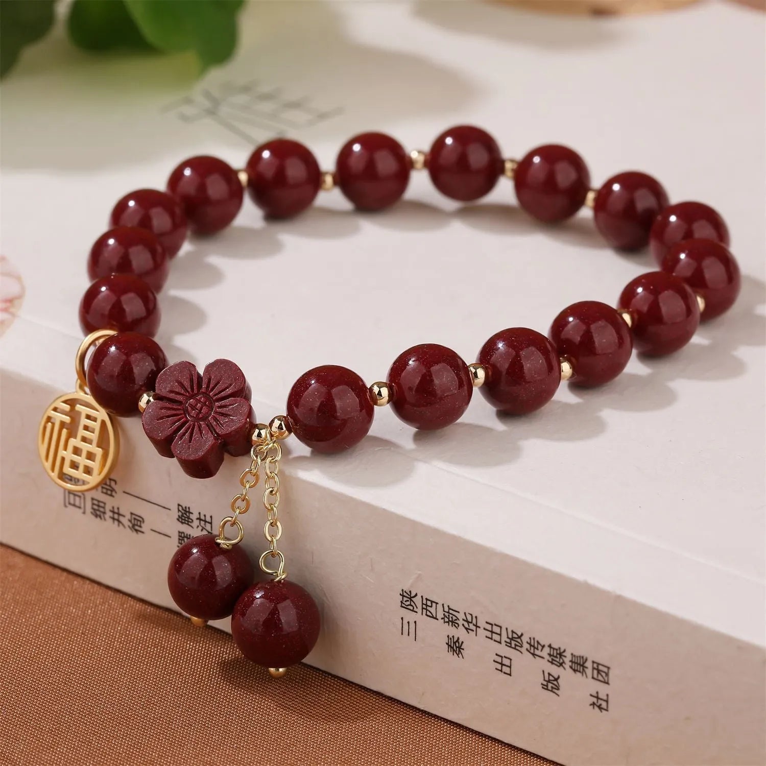 Close-up of a handmade purple gold sand cinnabar bracelet with a Fu character charm and peach blossom tassel.