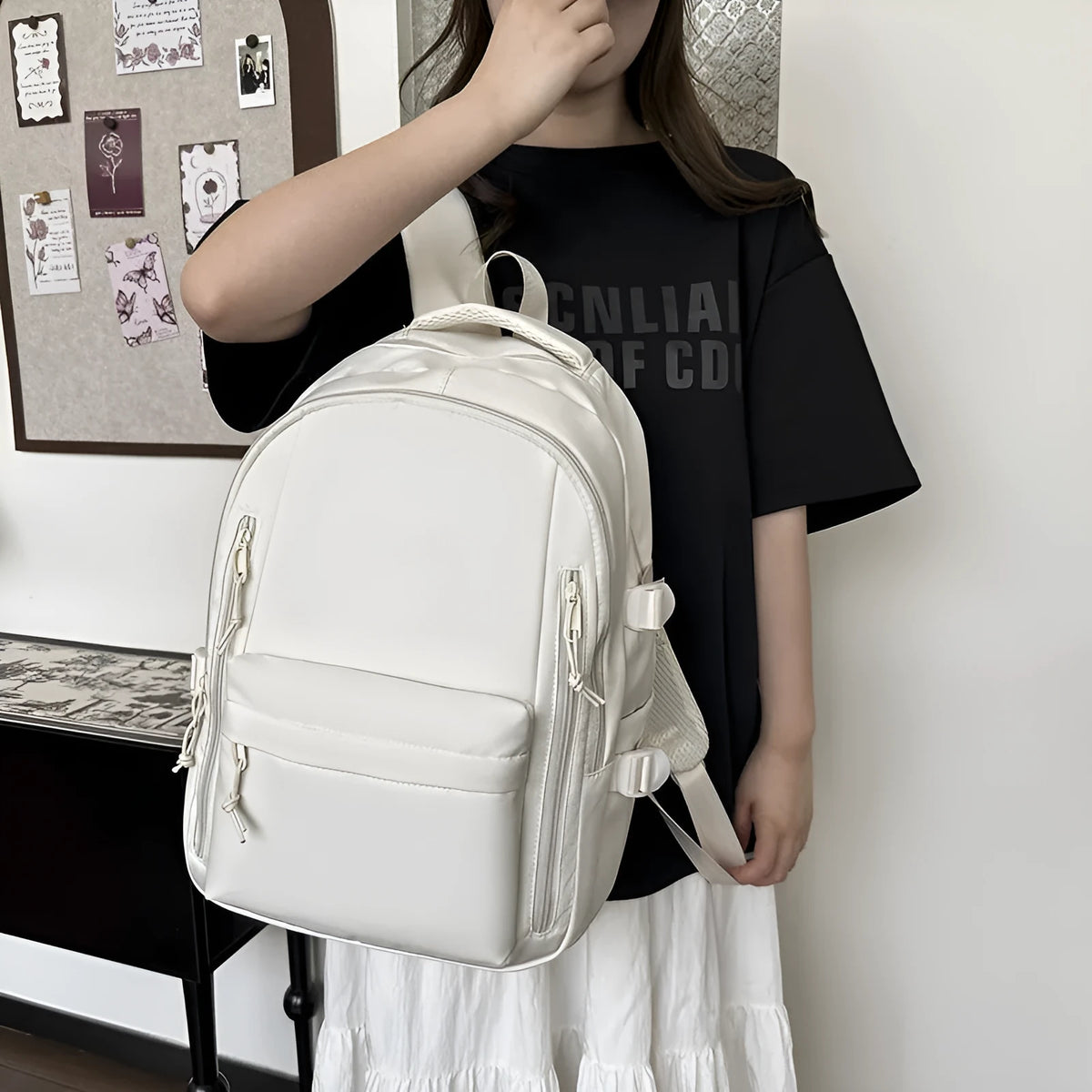 Large capacity nylon schoolbag in black or white, 20-35L, with curved shoulder straps and solid colour design.
