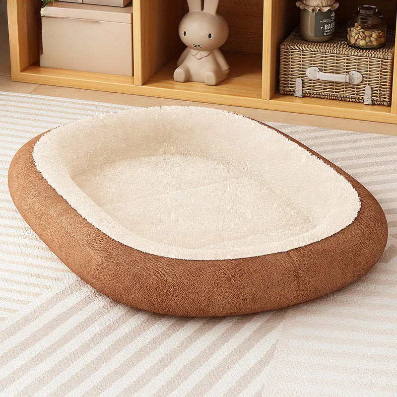 A grey thickened pet kennel with a fleece cover for a small dog resting inside on a wooden floor.