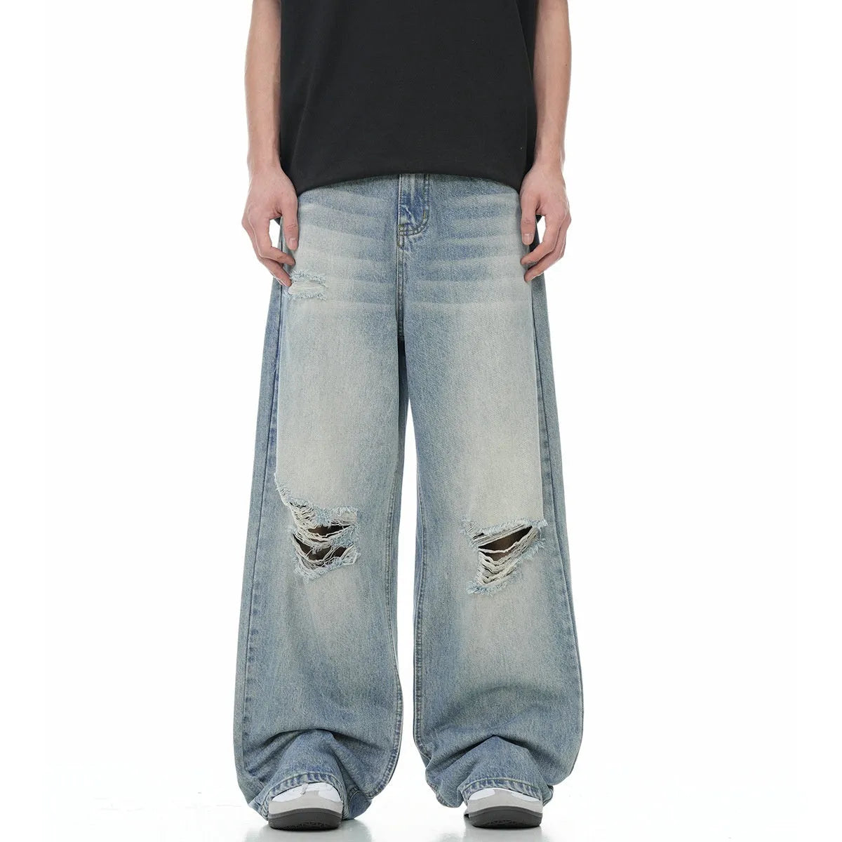 Man wearing blue retro-style straight-leg jeans with a ripped, distressed finish on the legs.