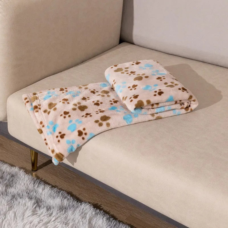 Blue cartoon dog pattern double-sided flannel pet blanket laid flat, showing its size next to a pet crate.