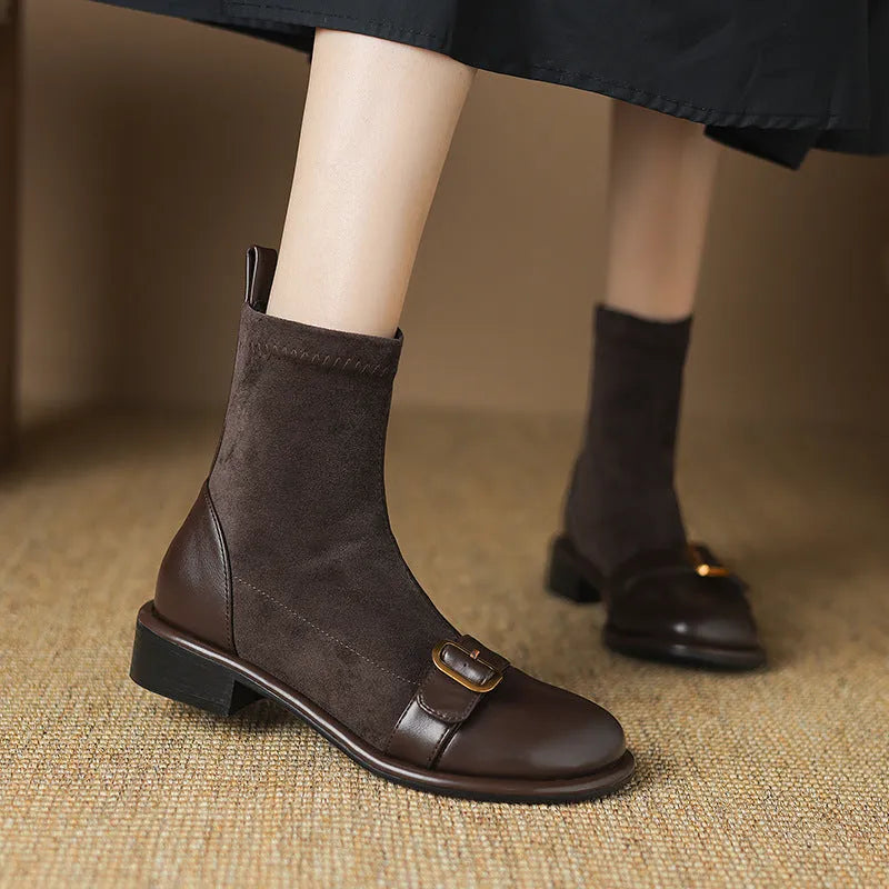 A pair of black women's lace-up Martin boots with a round toe and low rubber sole on a white background.