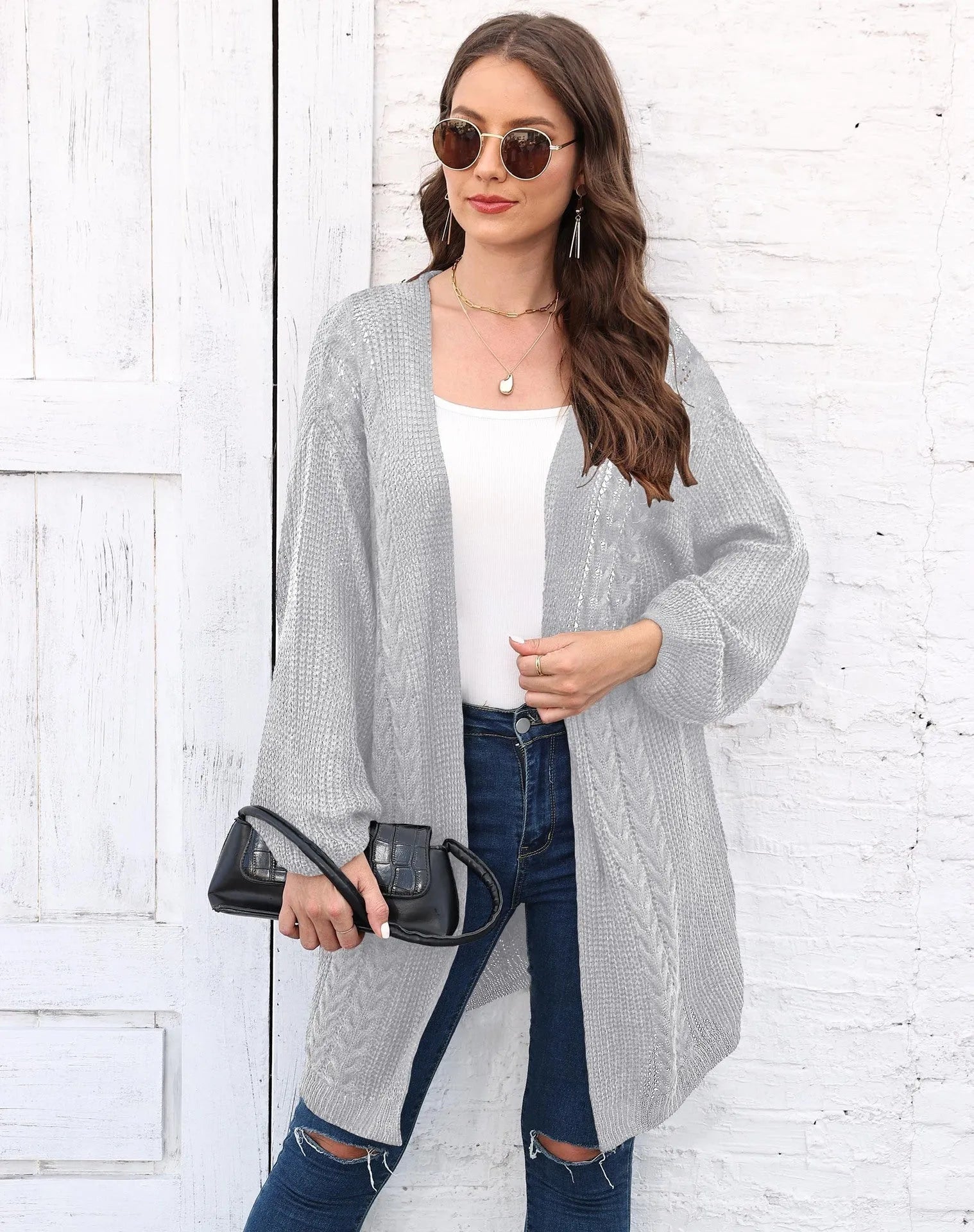 Women's loose fit acrylic sweater coat in a solid colour, shown in a casual setting.