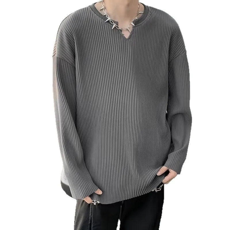 A person wearing a long sleeve striped pullover in a loose fit, available in black, white, or grey.