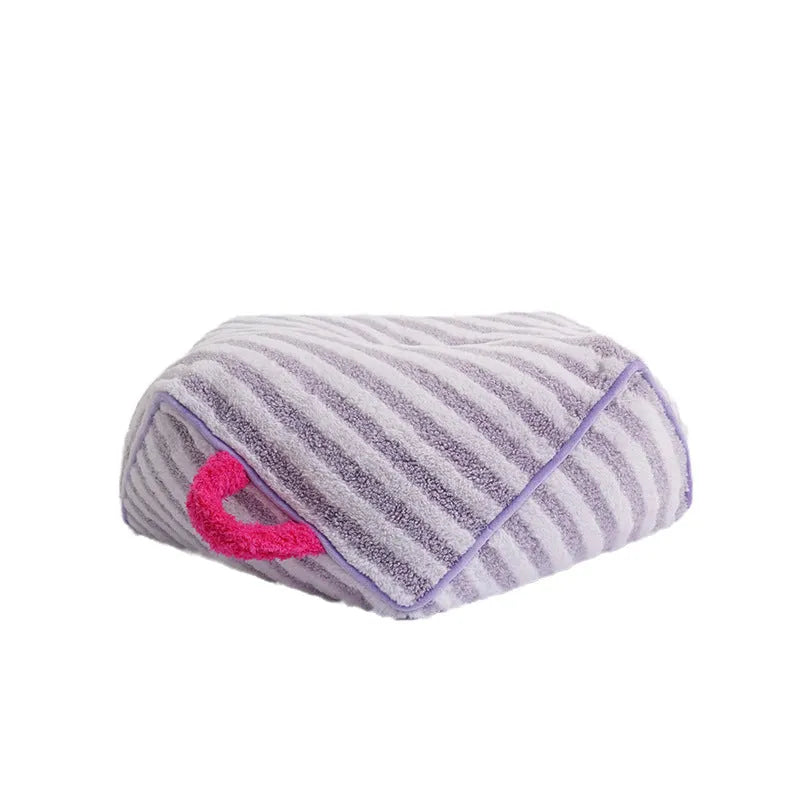Striped orange plush fabric dog bed with a removable cover on a wooden floor.