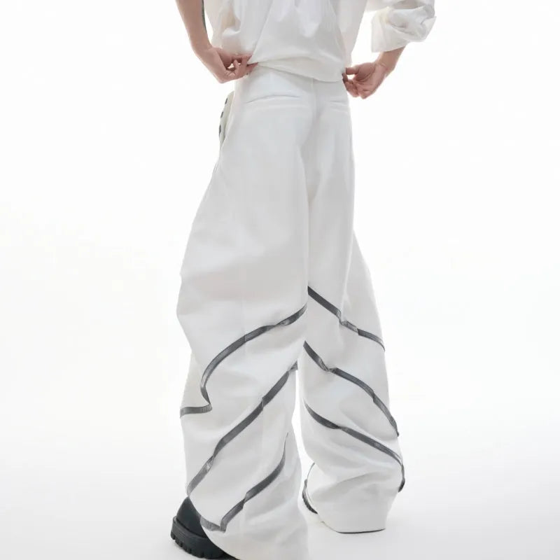 Men's black polyester trousers with metal striped rivets and pleated detail on a white background.