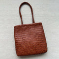 Brown woven leather tote bag with three-dimensional pockets measuring 27cm high by 30cm wide