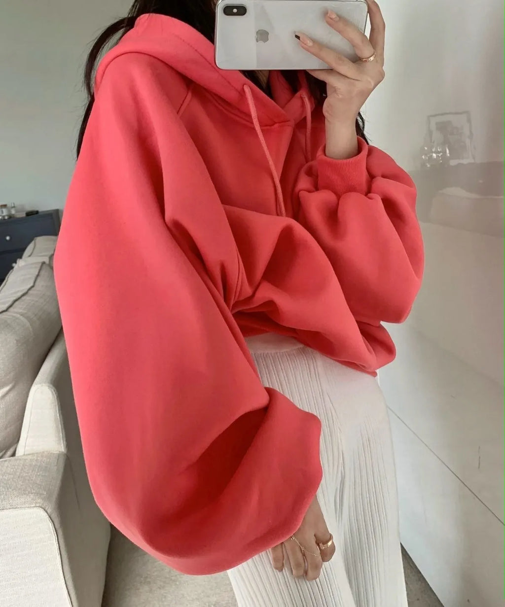 Watermelon red women's loose hooded sweater made from mulberry silk fabric on a hanger.