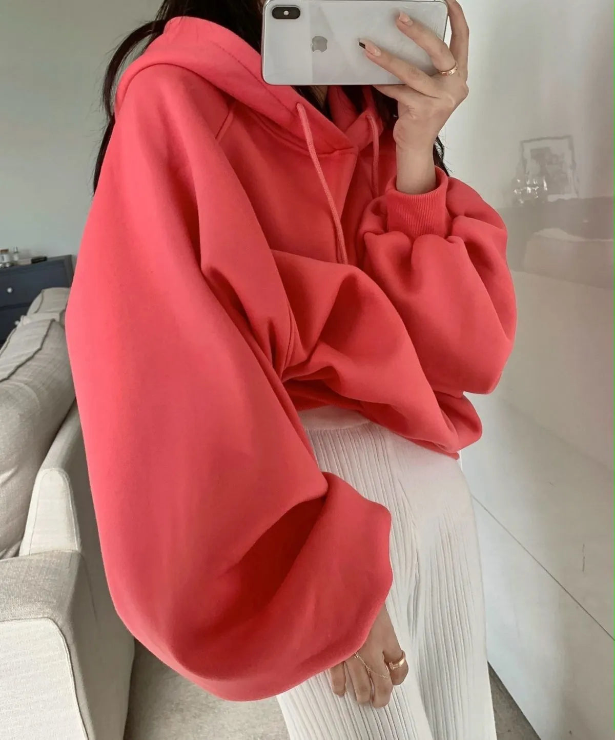 Watermelon red women's loose hooded sweater made from mulberry silk fabric on a hanger.