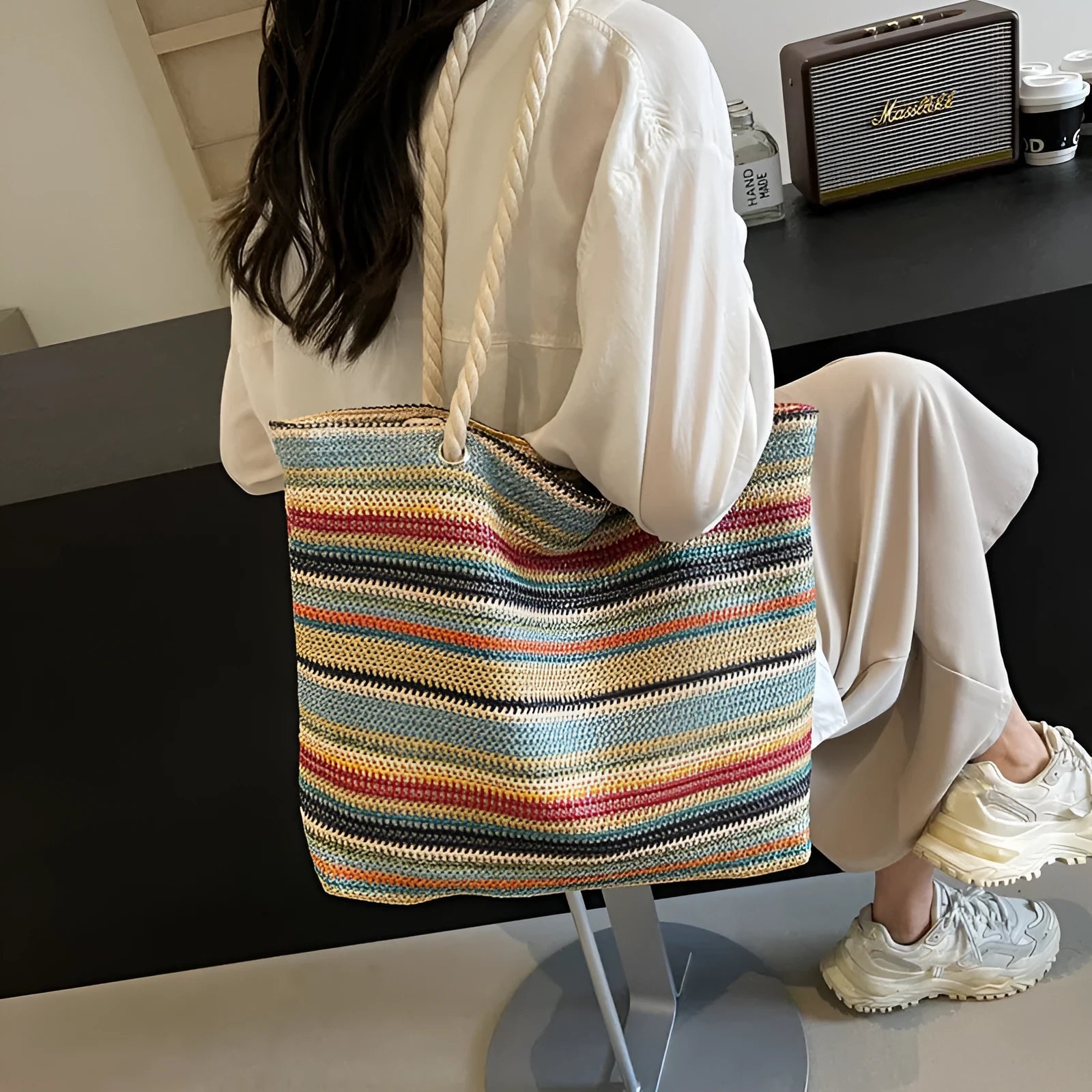 Blue woven nylon shoulder bag with adjustable strap showing straw-like texture pattern