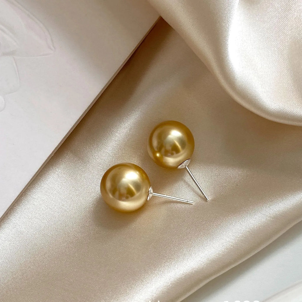 Close-up of retro-style geometric pearl stud earrings in silver, showing eight-awl star detail.